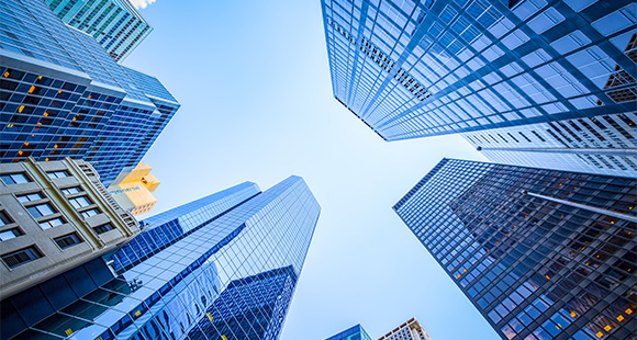 view of tall modern skyscrapers with reflective glass facades against a bright blue sky showcasing urban architecture and city life 4 buildings 4 stories 4 designs